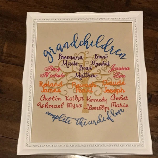 Tree Of Life Machine Embroidery stitch-out: Decorative piece with embroidered names of grandchildren on a wooden surface