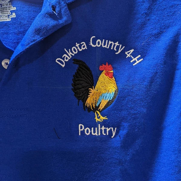 Golden Rooster Embroidery Design stitch-out: Blue polo shirt with Dakota County 4H Poultry logo on a blue background