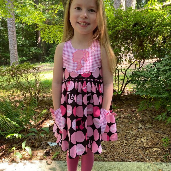 Girl Princess Head Silhouette stitch-out: Pink gingham dress with the princess silhouette applique on the bodice, worn by a