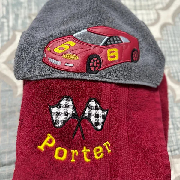 Racing Checkered Flag Applique Machine Embroidery stitch-out: Checkered Flag applique stitched out on a red towel.